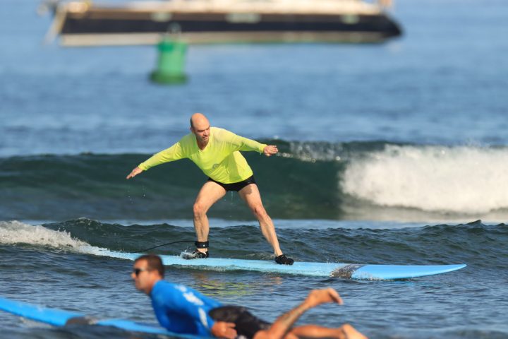 a man riding a wave on a surf board on a body of water