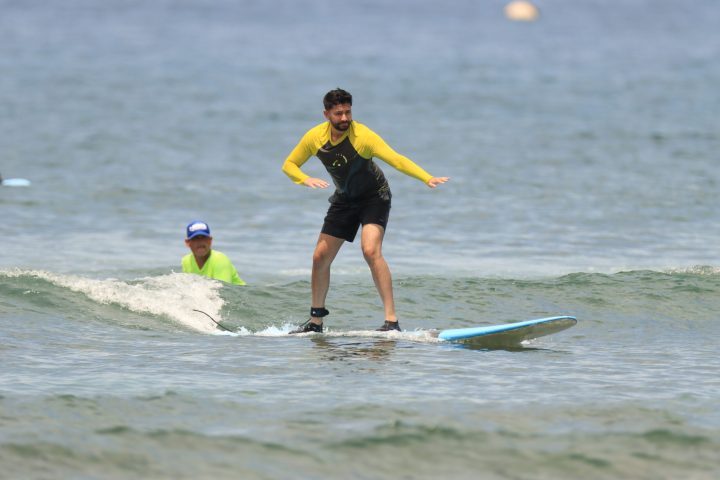 a man riding a wave on a surf board on a body of water